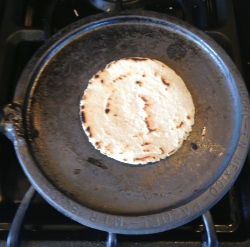 Flipped over to be baked on the second side, this tortilla shows the color and brown spots from a well-heated comal